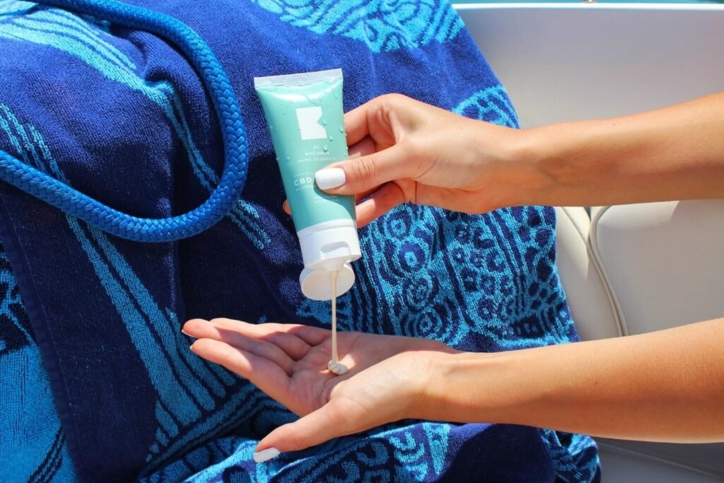 A woman putting sunscreen on her hand
